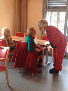 Nicht nur die alte Dame ist schwerhörig, heute auch die Pflegerin, weil sie einen Altersanzug trägt. Hier alle Infos anfordern für diese Fortbildung.